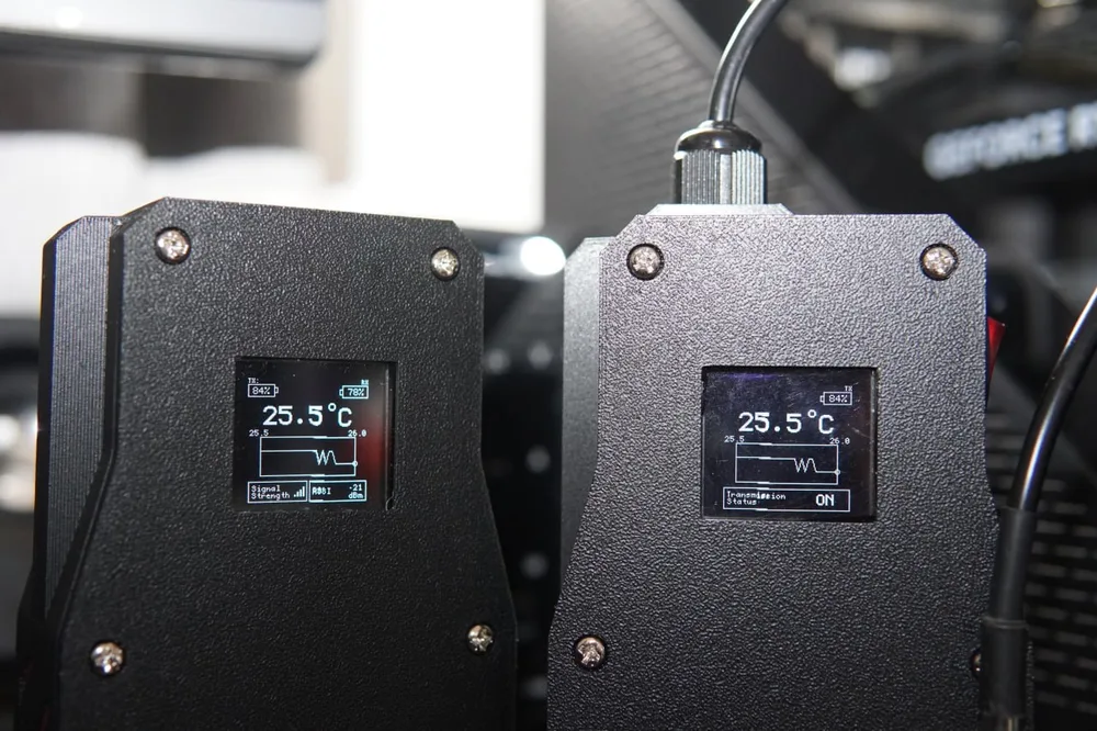 TempSense receiver and transmitter units showing live temperature data on their OLED screens